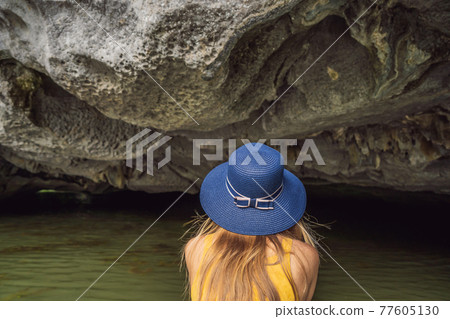 Woman tourist in boat on the lake Tam Coc, Ninh Binh, Viet nam. It's is UNESCO World Heritage Site, renowned for its boat cave tours. It's Halong Bay on land of Vietnam. Vietnam reopens borders after Woman tourist in boat on the lake Tam Coc, Ninh Binh, Viet nam. It's is UNESCO World Heritage Site, renowned for its boat cave tours. It's Halong Bay on land of Vietnam. Vietnam reopens borders after 77605130
