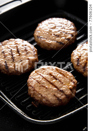 Cooked minced beef patty on grill pan. Cooking homemade burgers. Cooked minced beef patty on grill pan. Cooking homemade burgers. 77606104