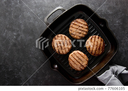Cooked minced beef patty on grill pan. Cooking homemade burgers. Copy space. Cooked minced beef patty on grill pan. Cooking homemade burgers. Copy space. 77606105