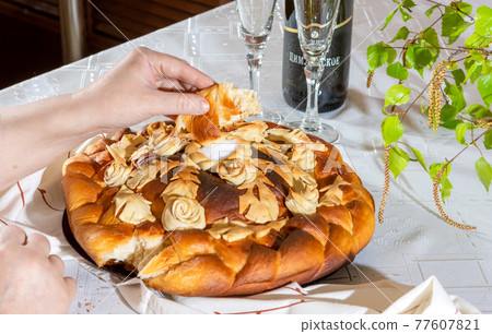 Bread with traditional decorations eaten on the table at the festival. Loaf wedding cake close-up Bread with traditional decorations eaten on the table at the festival. Loaf wedding cake close-up 77607821