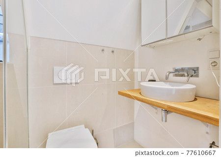 Simple bathroom design with toilet and wooden counter 77610667