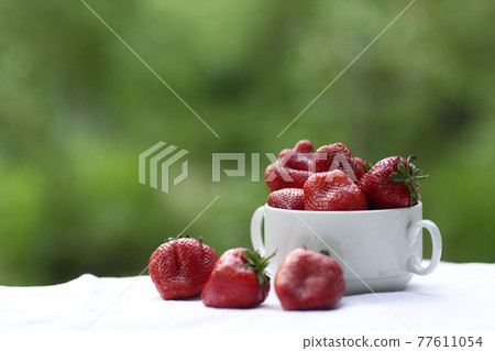 strawberry in bowl close up vertical photo with copy space on green grass background strawberry in bowl close up vertical photo with copy space on green grass background 77611054