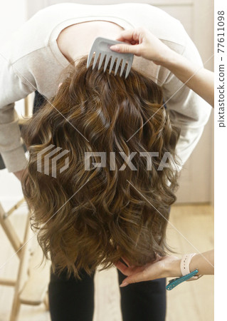 light brown long curly loose hair closeup photo in hair salon back view light brown long curly loose hair closeup photo in hair salon back view 77611098