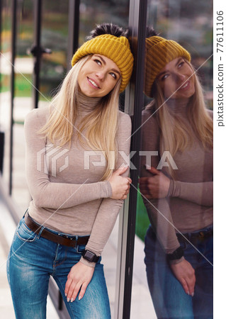 blond lgirl in knitted hat and scarf with coffee paper glass close up portrait in cafe  77611106