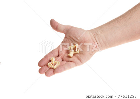Hand holds a plastic dowel for screws on a white background 77611255