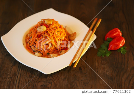 Spicy Korean-style carrot salad on a dark background. Koryo-saram cuisine Spicy Korean-style carrot salad on a dark background. Koryo-saram cuisine 77611302