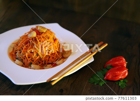 Spicy Korean-style carrot salad on a dark background. Koryo-saram cuisine Spicy Korean-style carrot salad on a dark background. Koryo-saram cuisine 77611303