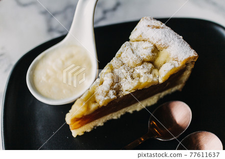 Close up of Apple Crumble Cake in dark classic cafe. 77611637