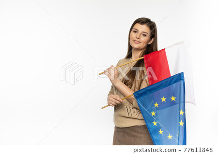 Young girl with the flag of the European Union and Poland. The student is holding two flags in her hand. Woman with flags on white background. Young girl with the flag of the European Union and Poland. The student is holding two flags in her hand. Woman with flags on white background. 77611848