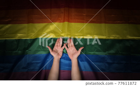 LGBTQ pride flag. Lesbian Gay Bi sexsual Transgender Queer. Homosexsual pride Rainbow flag in gay hand. black background. Represent symbol of freedom, peace, equality and love. LGBTQ concept. 77611872