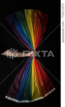 LGBTQ pride flag. Lesbian Gay Bi sexsual Transgender Queer. Homosexsual pride Rainbow flag in gay hand. black background. Represent symbol of freedom, peace, equality and love. LGBTQ concept. 77611873