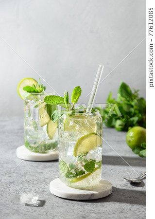 Mojito with lime, mint and ice cube on gray background. 77612085