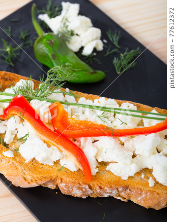 Canape with young cheese and pepper 77612372