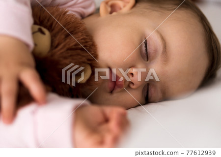 Authentic portrait cute caucasian little infant chubby baby girl or boy in pink sleep with teddy bear on white bed. child resting at lunchtime. care, Sleeping kid, Childhood, Parenthood, life concept 77612939