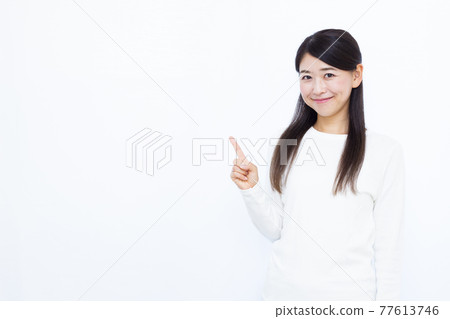 A woman in her thirties pointing 77613746