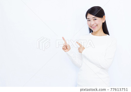 A woman in her thirties pointing 77613751