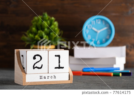 March 21st. March 21 wooden cube calendar with blur objects on background. March 21st. March 21 wooden cube calendar with blur objects on background. 77614175