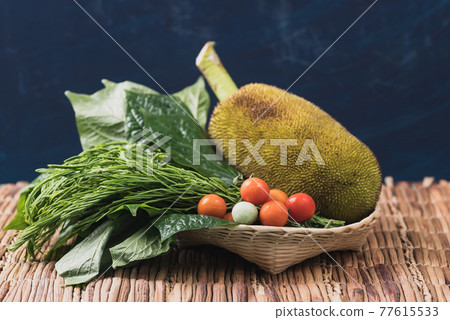 Young jackfruit and local vegetables in a basket, Food ingredients for Northern Thai food Young jackfruit and local vegetables in a basket, Food ingredients for Northern Thai food 77615533