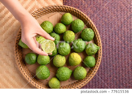 Fresh bergamot fruit holding by woman hand Fresh bergamot fruit holding by woman hand 77615536