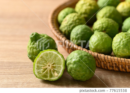 Fresh bergamot fruit in a basket on wooden table Fresh bergamot fruit in a basket on wooden table 77615538