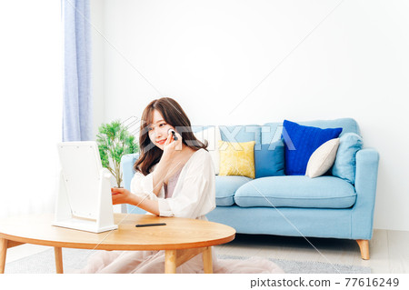 Young woman doing make-up at home 77616249