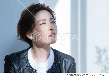 Genderless LGBT woman wearing a leather jacket 77617372