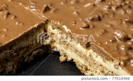 Slice of Swedish almond and chocolate cake with filling and nuts 77618466