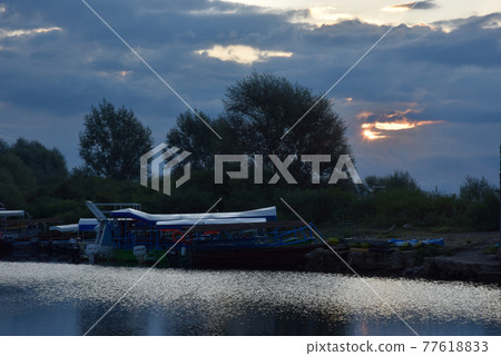 At dawn, the sun appears, the clouds change color, and there is silence on the river. At dawn, the sun appears, the clouds change color, and there is silence on the river. 77618833