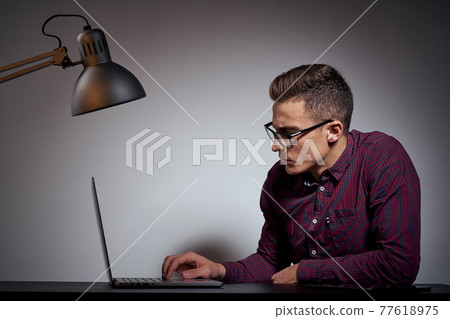 businessman in glasses and a shirt sits at a table with open laptops Coffee Space mobile phone businessman in glasses and a shirt sits at a table with open laptops Coffee Space mobile phone 77618975