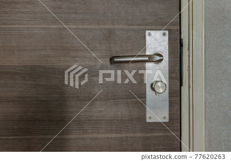 Detail of a Door knob or handle and keyhole made of Stainless on the wooden door horizontal. Detail of a Door knob or handle and keyhole made of Stainless on the wooden door horizontal. 77620263