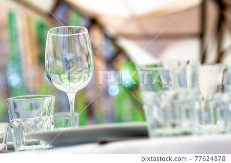 Table for guests, are served with cutlery and crockery and covered with a tablecloth. Table for guests, are served with cutlery and crockery and covered with a tablecloth. 77624878