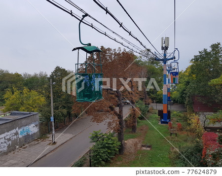 View of a famous cable car in Odessa with the sea in the background. Colored cabins. Travel background. View of a famous cable car in Odessa with the sea in the background. Colored cabins. Travel background. 77624879