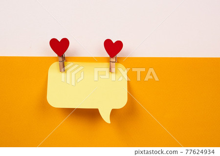 a note on a yellow piece of paper and a wooden clothespin with a heart Creativity Copy Space 77624934
