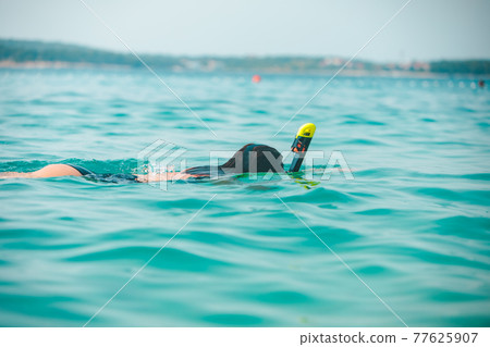 woman in snorkeling mask in sea water woman in snorkeling mask in sea water 77625907