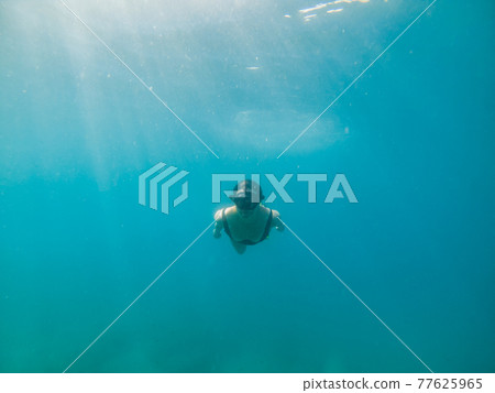 woman in snorkeling mask and flippers under water 77625965