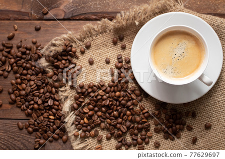 Photo Roasted coffee beans, ground coffee and cup of coffee on wooden table