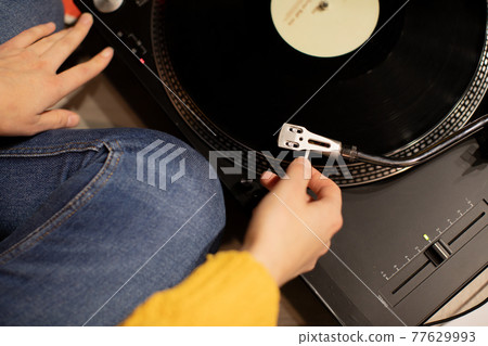 girl hand put tonearm on vinyl record starting turntable Sound meditation 77629993
