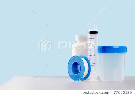 Medical mockup plastic jars and syringe on blue 77630129