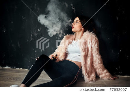 Sexy trendy rap woman in pink fur coat smoke... - Stock Photo