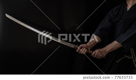 A person holding a Japanese sword A person holding a Japanese sword 77633733