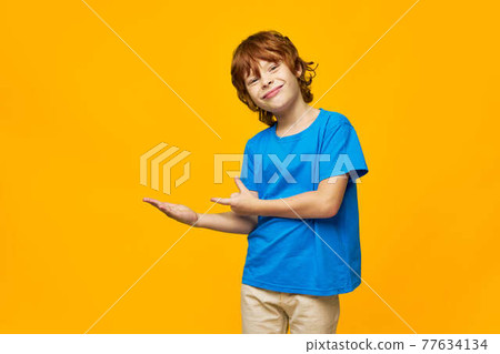 red-haired child freckles show with hands to the side and smirk on the face 77634134