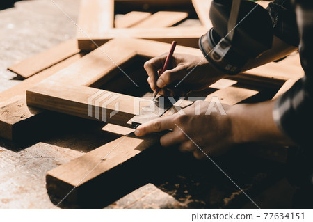 The carpenters high experienced wood worker making furniture. master of woodcraft male work with wooden handcraft piece with fine detail. The carpenters high experienced wood worker making furniture. master of woodcraft male work with wooden handcraft piece with fine detail. 77634151