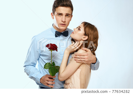 Man and woman with a red rose on a light background love family hugs 77634282