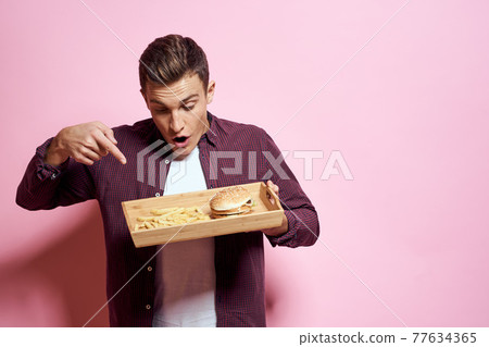 Man with wooden pallet fast food diet food lifestyle pink background 77634365