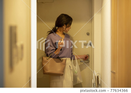 Woman locking the door 77634366