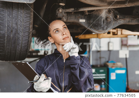 Women mechanic worker thinking. Garage staff female think day dream or forget check list auto service. 77634505