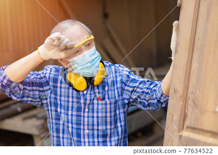 Tired exhausted elder Asian labor hard work in hot place wiping head sweat waring face mask for COVID-19 and dust protective. Tired exhausted elder Asian labor hard work in hot place wiping head sweat waring face mask for COVID-19 and dust protective. 77634522
