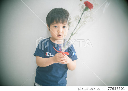 3-year-old child with a bouquet of carnations 77637501