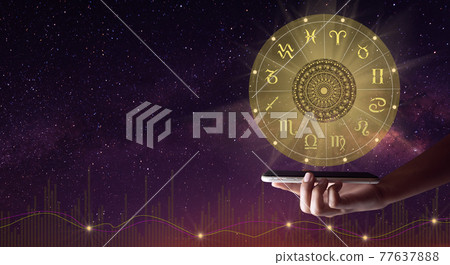 Human holding a mobile with zodiac wheel hologram and mandala. The Milky way and life graph background. Copy space. 77637888