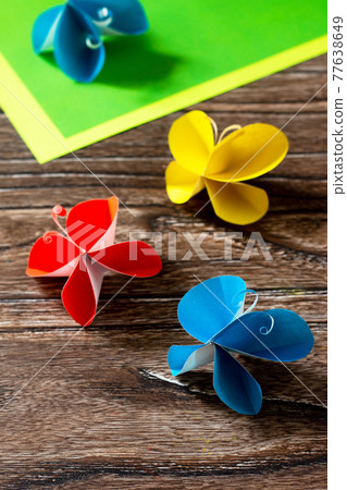 Butterfly paper decor or summer garland on a wooden table. Handmade paper ideas. The project of children's creativity, crafts, crafts for children. 77638649